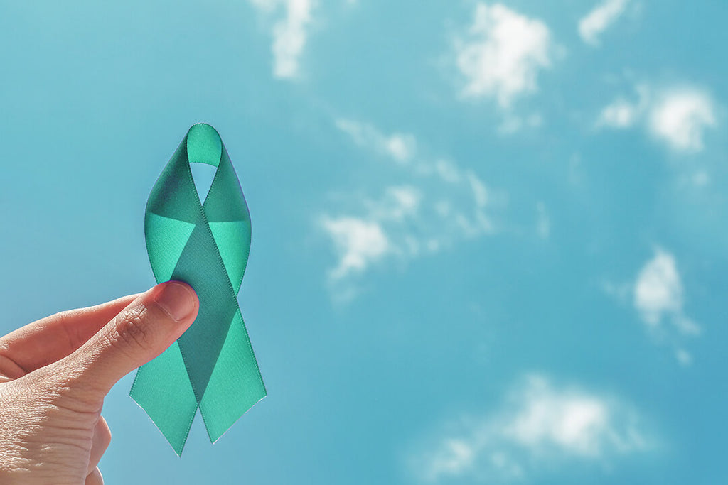 green ribbon held up against blue sky